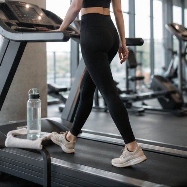 A woman walking on a treadmill at the gym