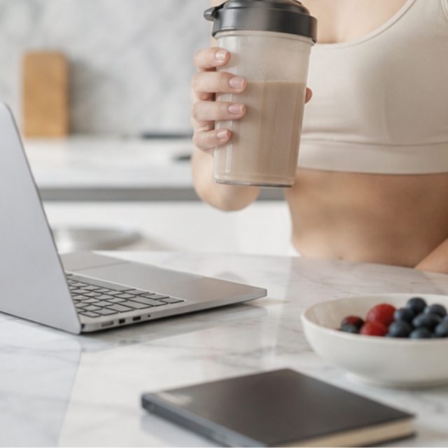 A meal-replacement shake in a shaker bottle at a desk